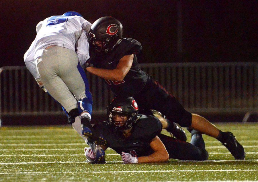 Camas defensive backs Trevor Bentley, bottom, and Shane Jamison work together to bring Coeur d'Alene receiver Kyle Pendergast down at Doc Harris Stadium in Camas on Friday, September 22, 2017. Camas beat Coeur d'Alene 28-25. 
(Samuel Wilson for the Columbian)