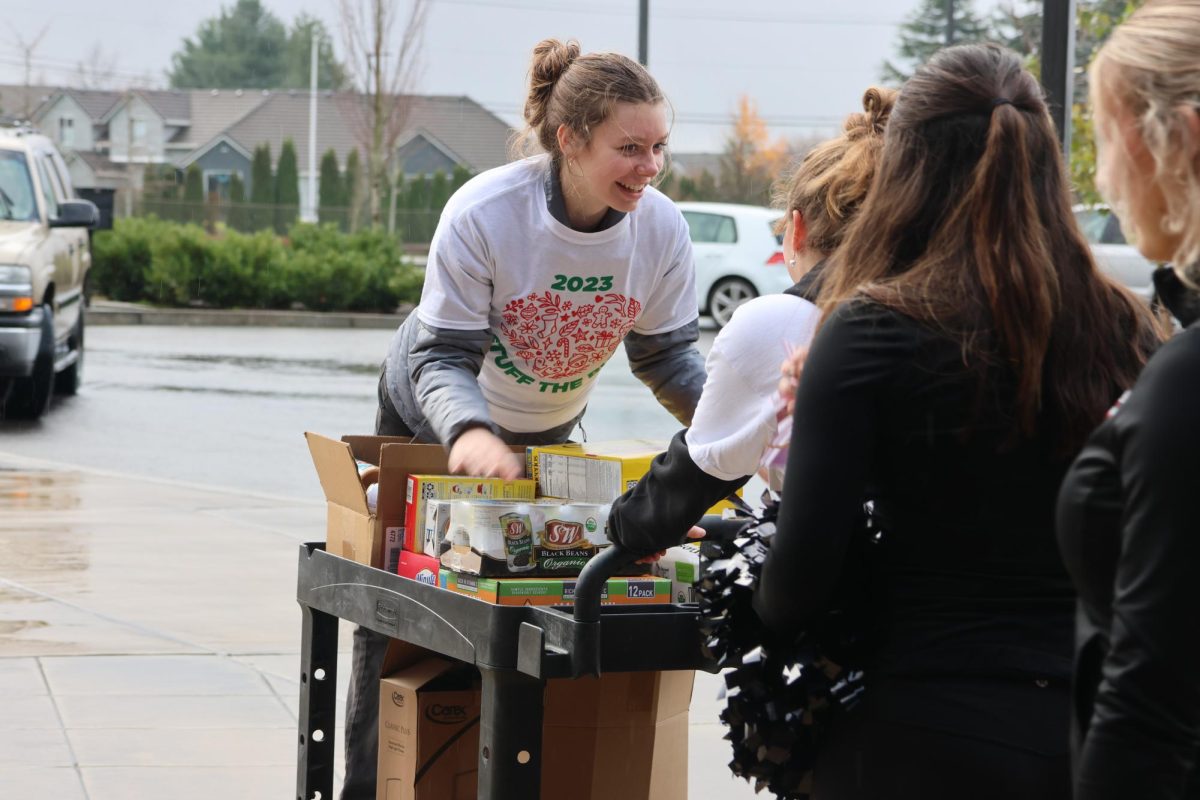 CHS student helps transport food donations to those in need at Stuff the Bus, courtesy of CHS Yearbook