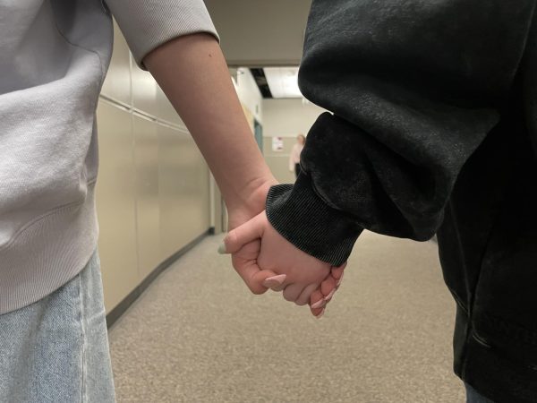 Two students walk the halls hand-in-hand