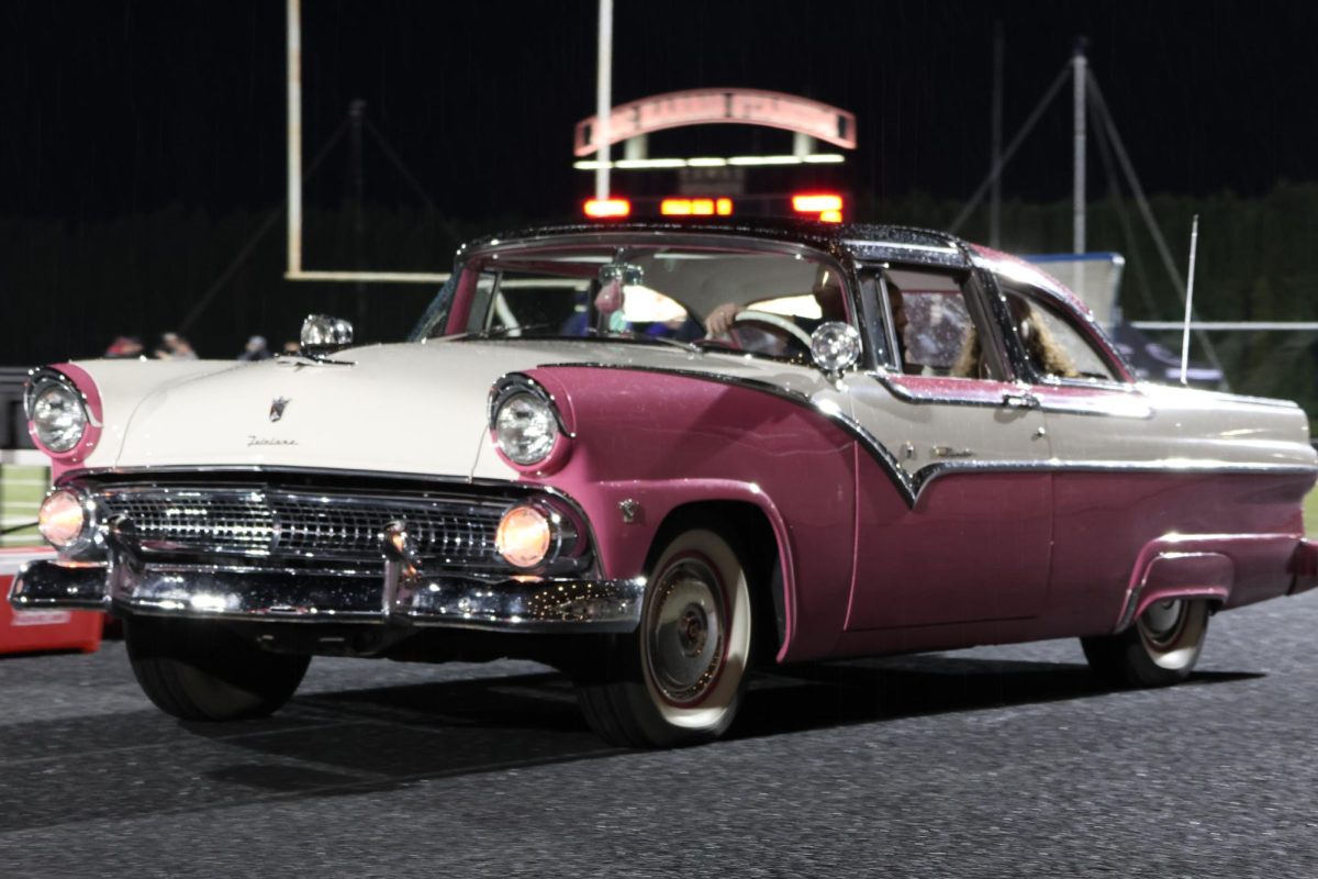 CHS Senior Homecoming Royalty rolling across the track during the Camas Football homecoming game